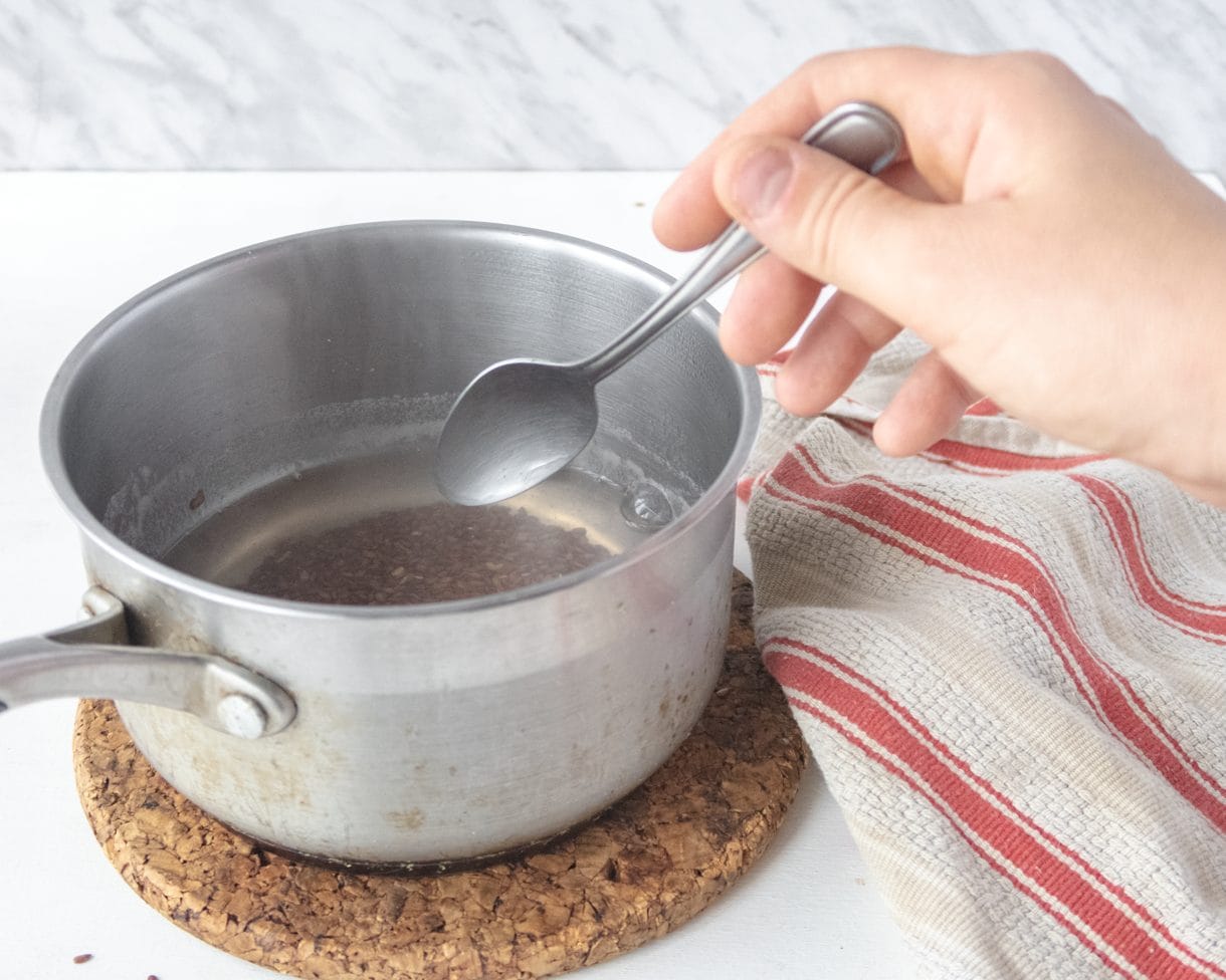 Freshly cooked Aqua-Flaxa in a saucepan with a hand stiring