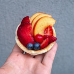 vegan fresh fruit tartlets held up in the palm of a hand