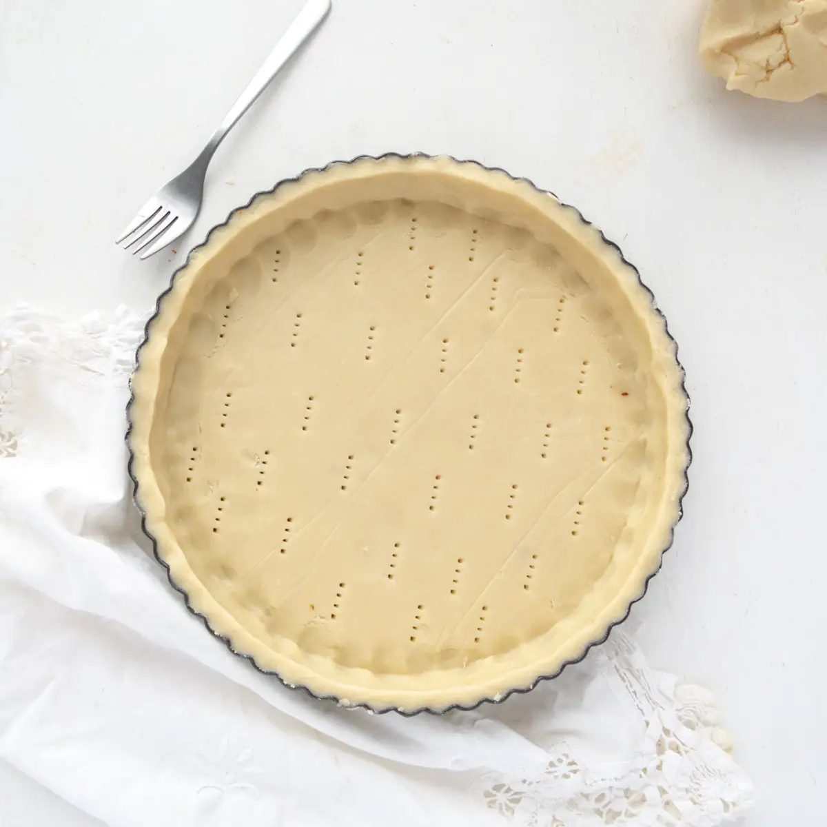 uncooked sweet pastry dough lined flutted tart pan