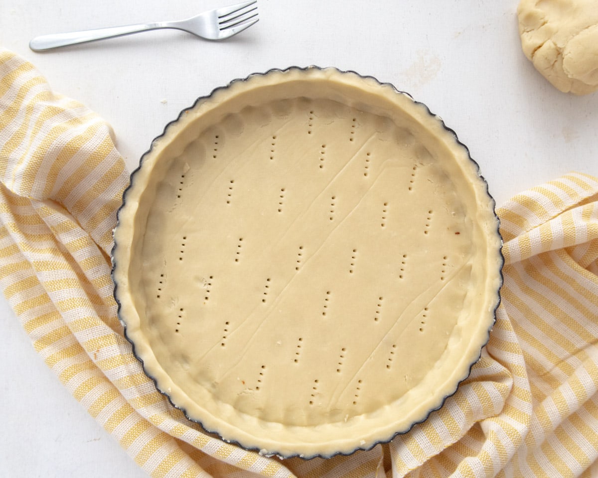 top down view of a tart shell on a yellow 