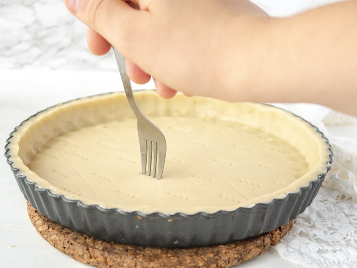 fork pricking the bottom of a tart shell