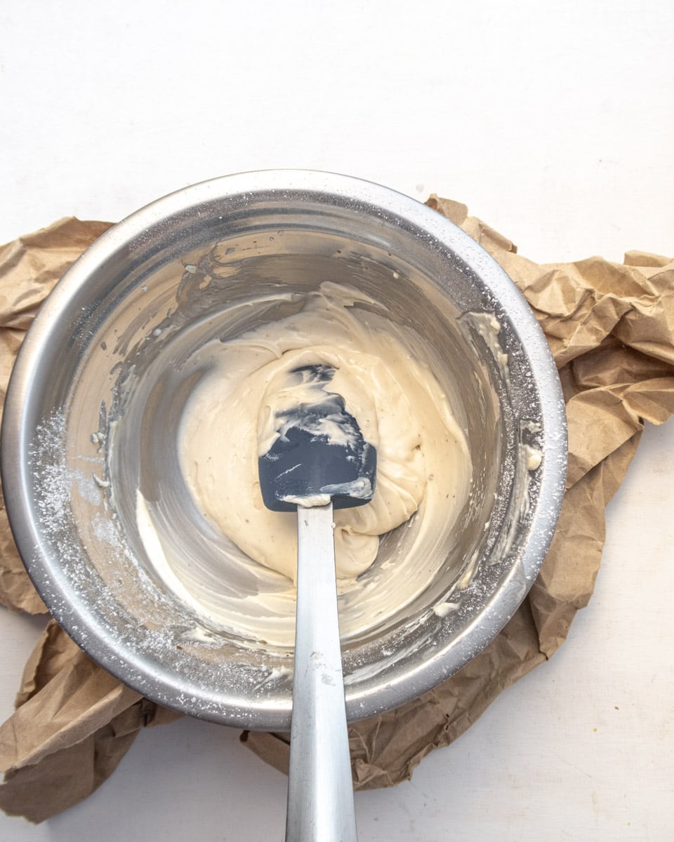 Vegan Cream cheese icing in a metal bowl on a white background
