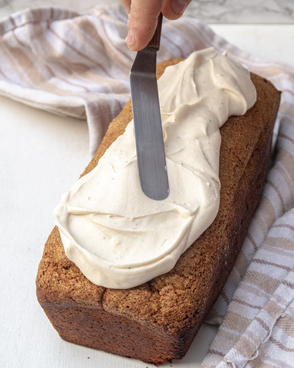 pumpkin bread in the process of being frosted with cream cheese icing