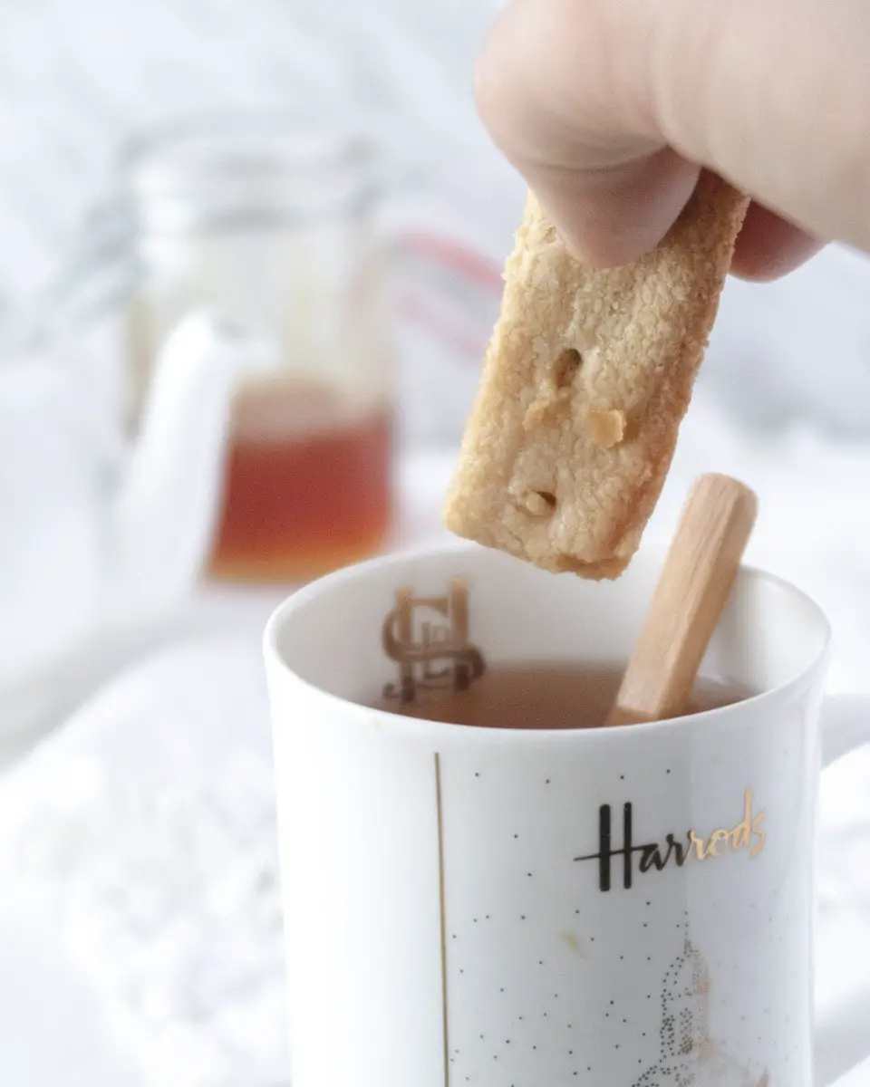 gluten-free shortbread being dipped in a cup of tea