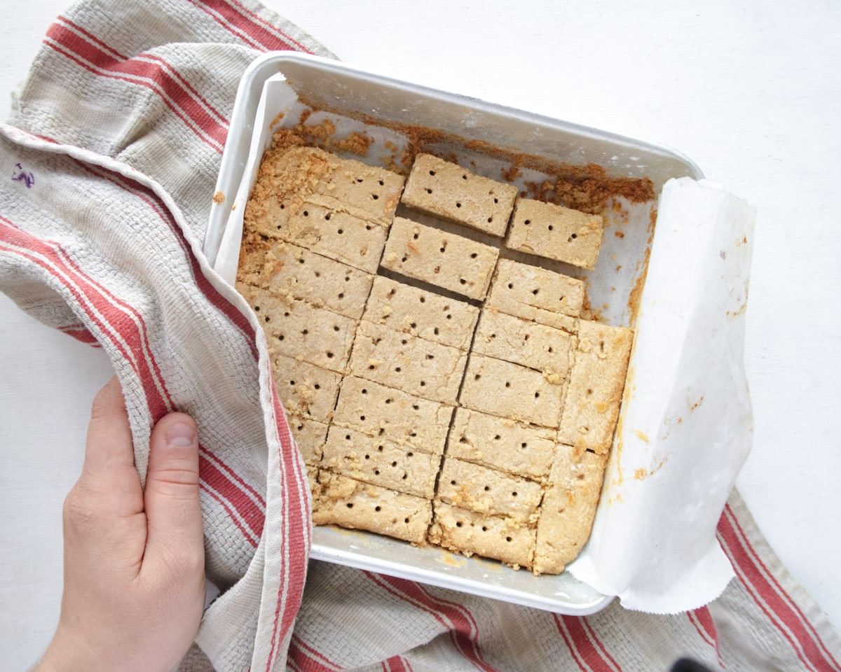 vegan shorbread cookies in a square pan on top of a red stripped dishcloth