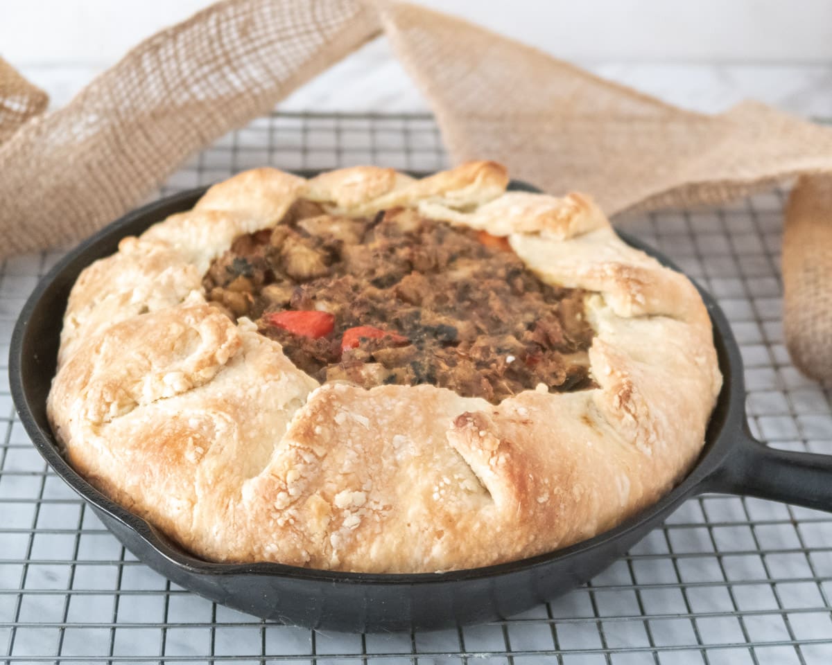 rustic chickpea pie on a wirer rack with a ribbon in the background