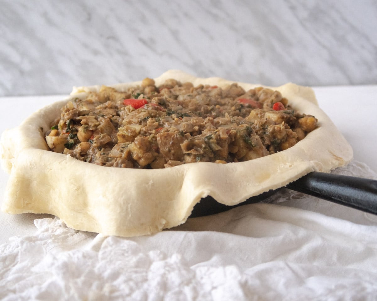 rustic pie being filled with the top unfolded