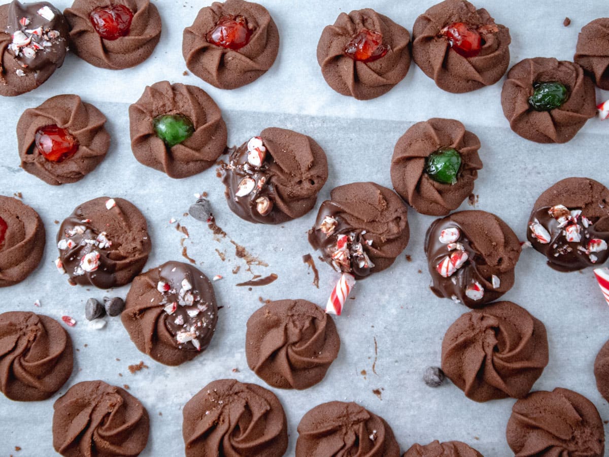 A variety of of chocolate piped cookies on a baking tray