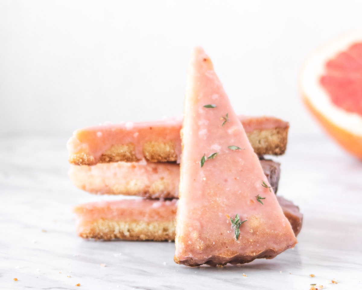 3 shortbreads stacked with a fourth one leaning on the other cookies in front of a white background