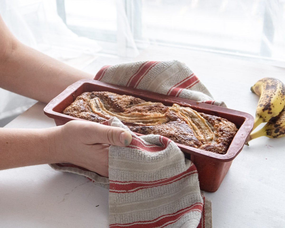 freshly baked baba loaf heldup by 2 hands