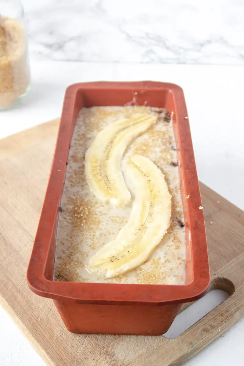 unbaked banana bread in a red silicone loaf pan
