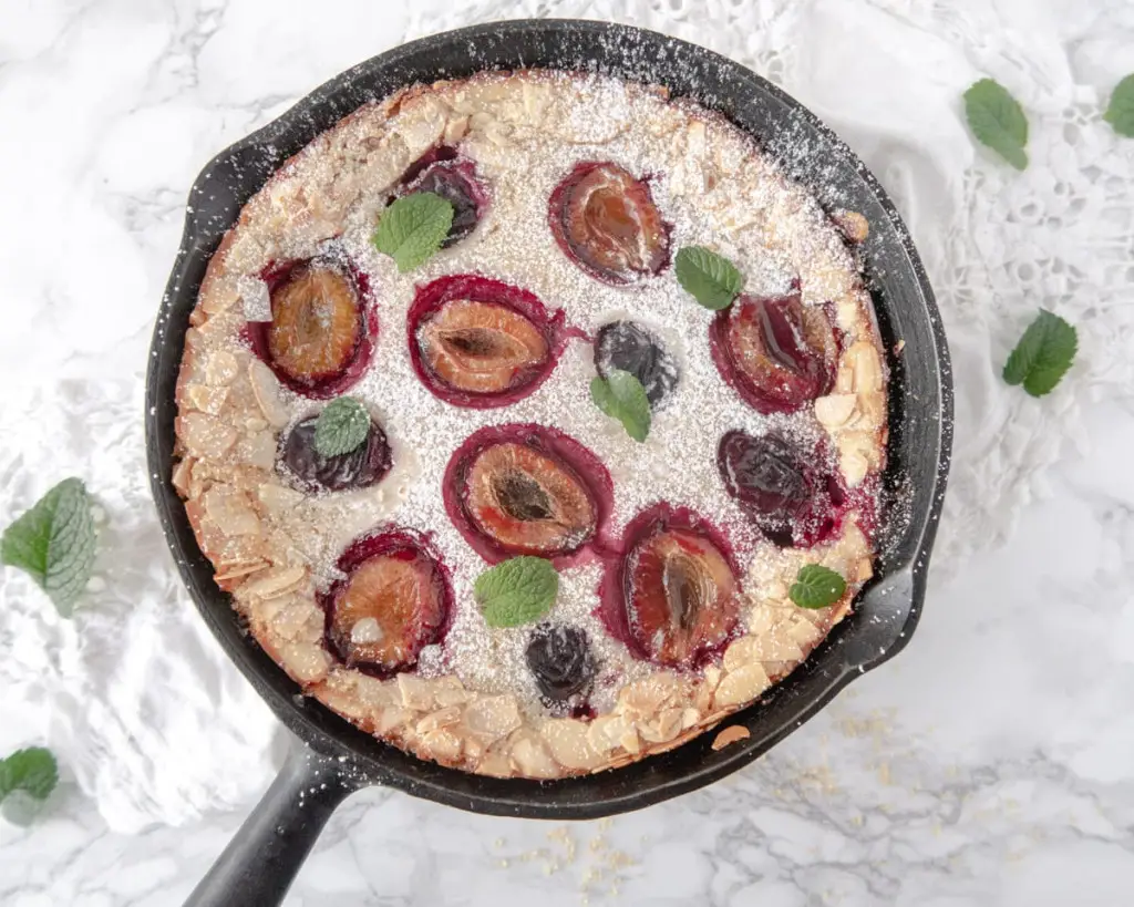 Top down view of a plum clafoutis in a cast iron skillet