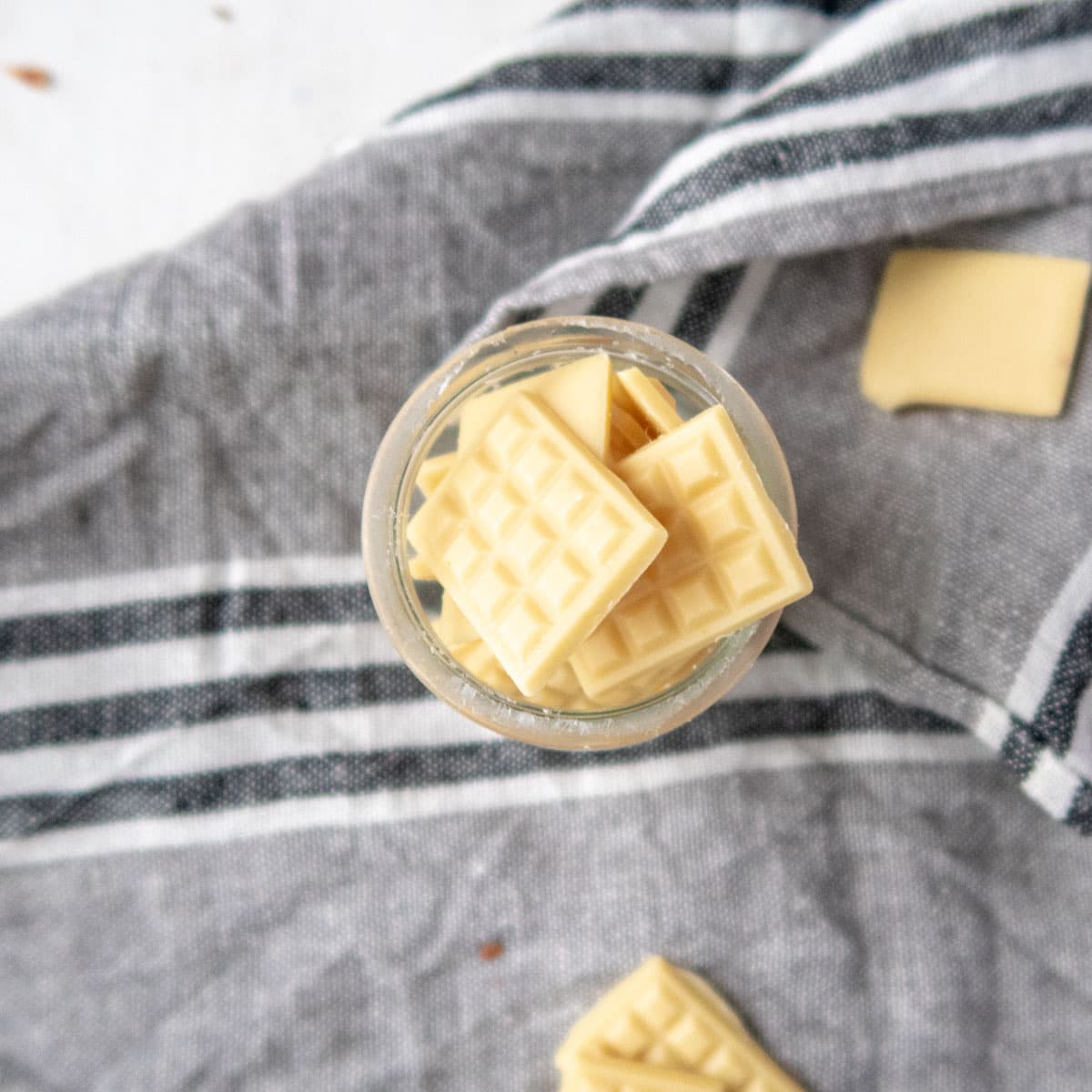 mini vegan white chocolate bars in a jar on top of a grey towel