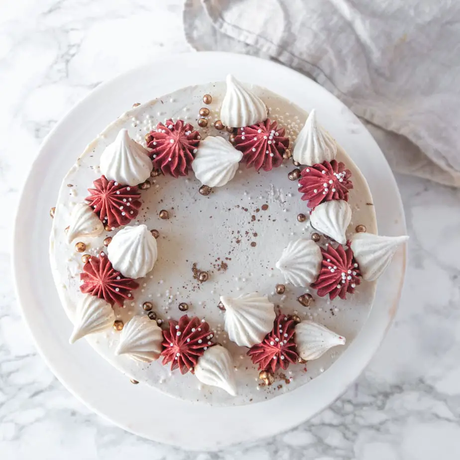 overhead view of the cake, which has burgundy piped rosette and is garnished with tiny meringues