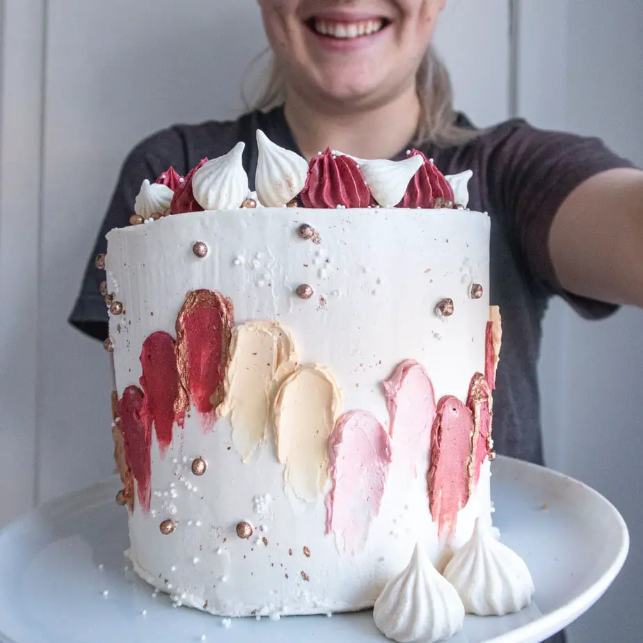 Fully decorated cake being held in front of a person