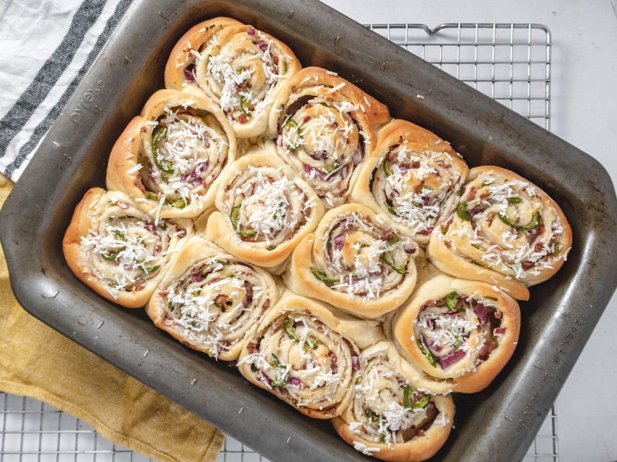 a dozen of golden brown vegan jalapeno popper rolls in a pan