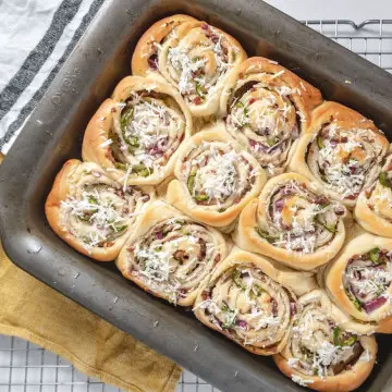 a dozen of golden brown vegan jalapeno popper rolls in a pan