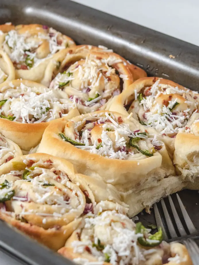 side view of baked vegan jalapeno popper rolls still in the baking dish