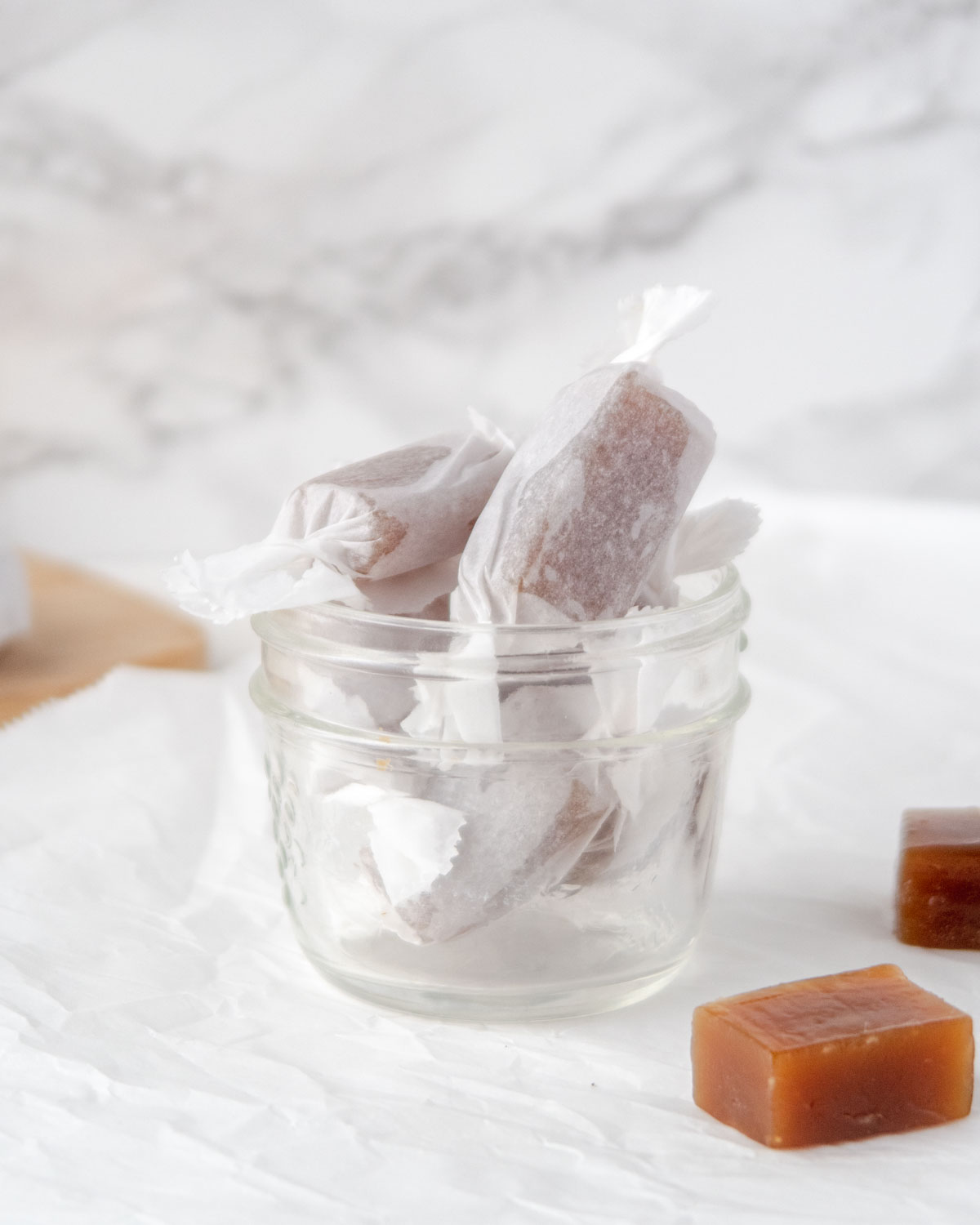 parchment paper wrapped vegan caramels in a mason jar