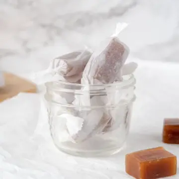 parchment paper wrapped vegan caramels in a mason jar