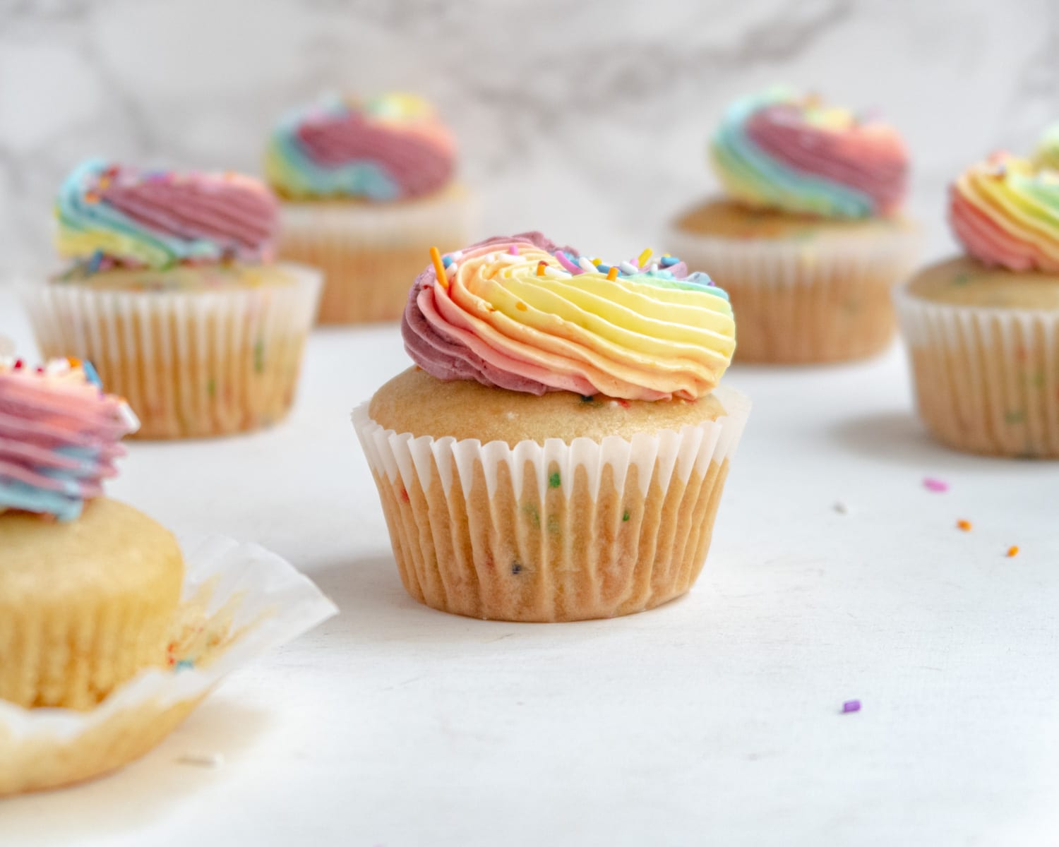 Pride cupcake with blury funfetti cupcakes in the background