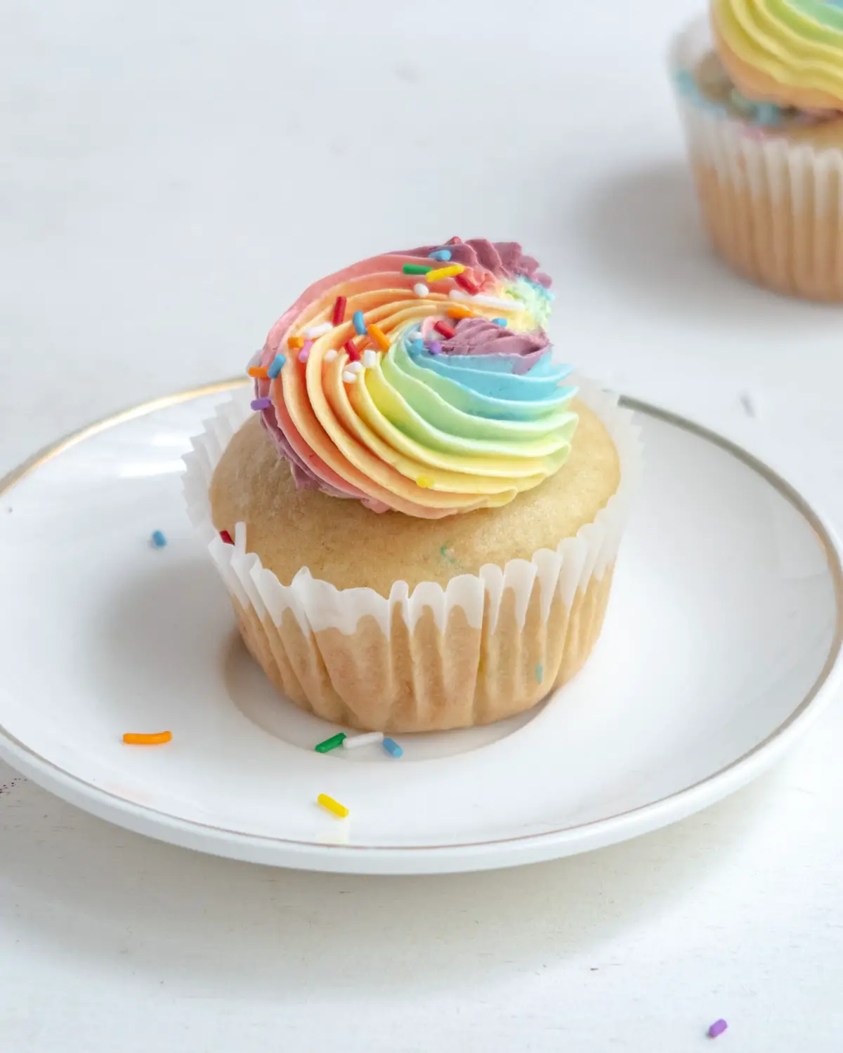 rainbow pride cupcake on a small white palte with sprinkles
