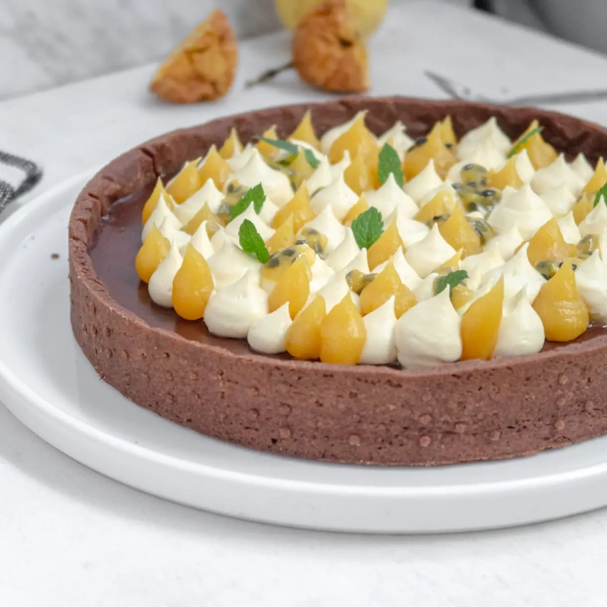 Vegan dark chocolate ganache-filled tart topped with passionfruit white chocoalte whipped ganache and passionfruit curd.