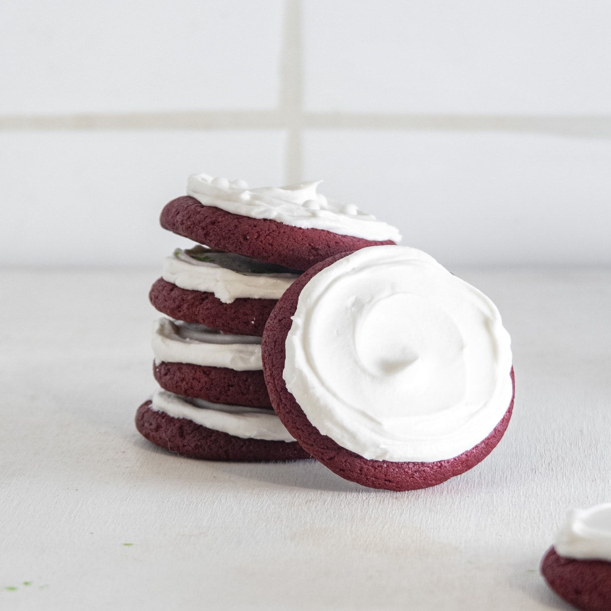 a red velvet cookie leaning on a tower made of 4 more cookies