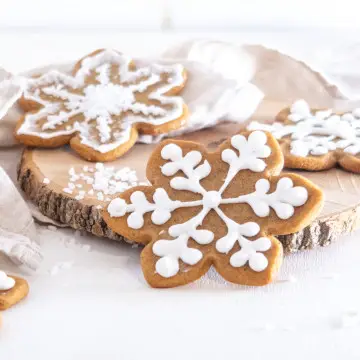 Snowflake-shapped cookies decorated with vegan royal icing