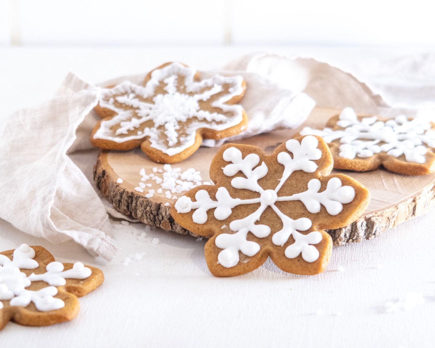 Snowflake-shapped cookies decorated with vegan royal icing