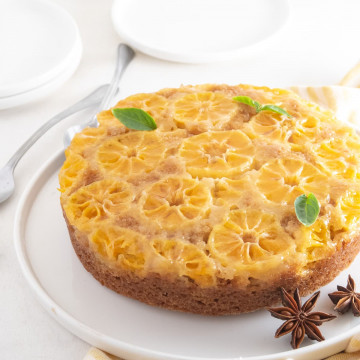 clementine upside down cake in a white plate with star anise and mint garnish