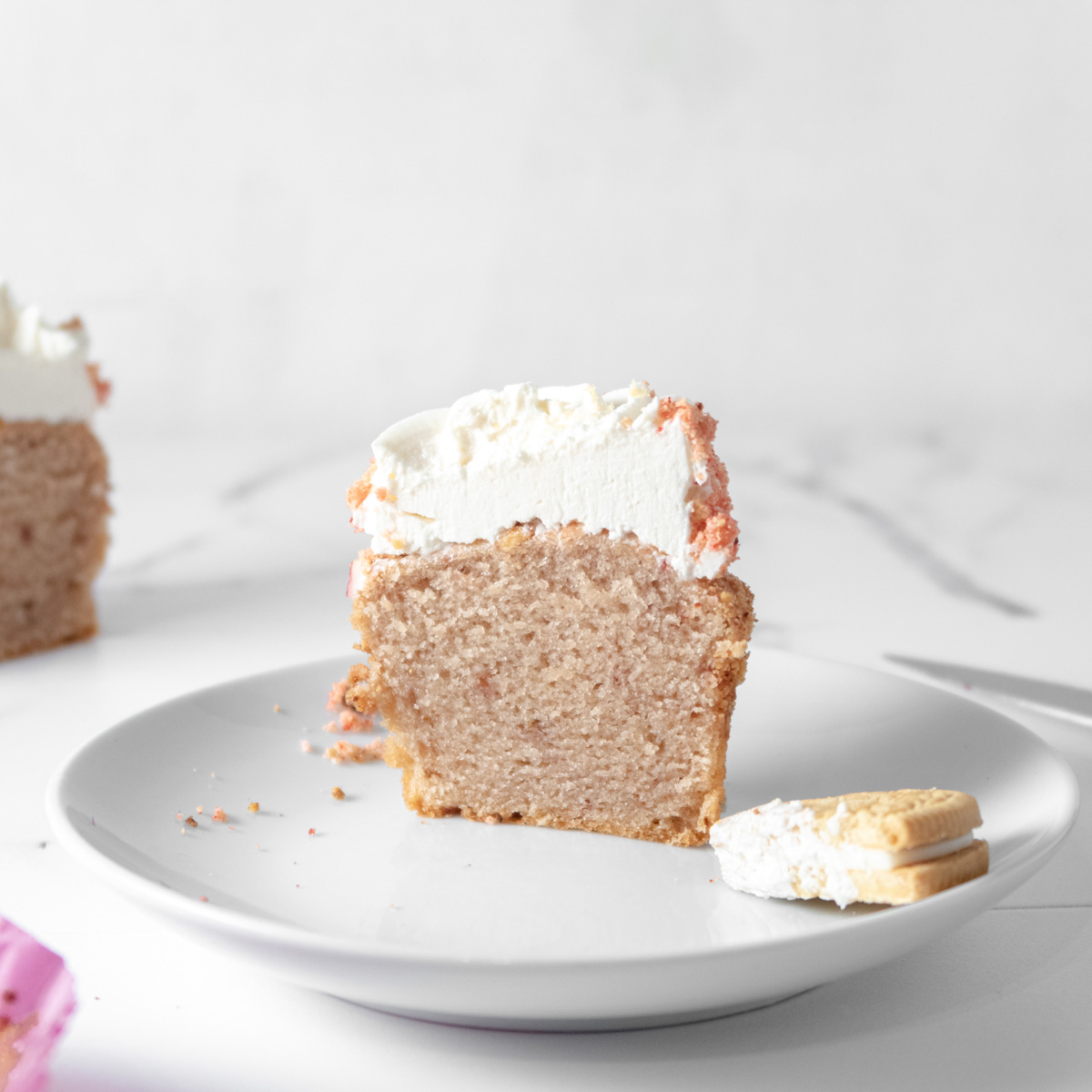 Vegan Strawberry crunch cupcake cut on half on a plate to show the crumb texture.