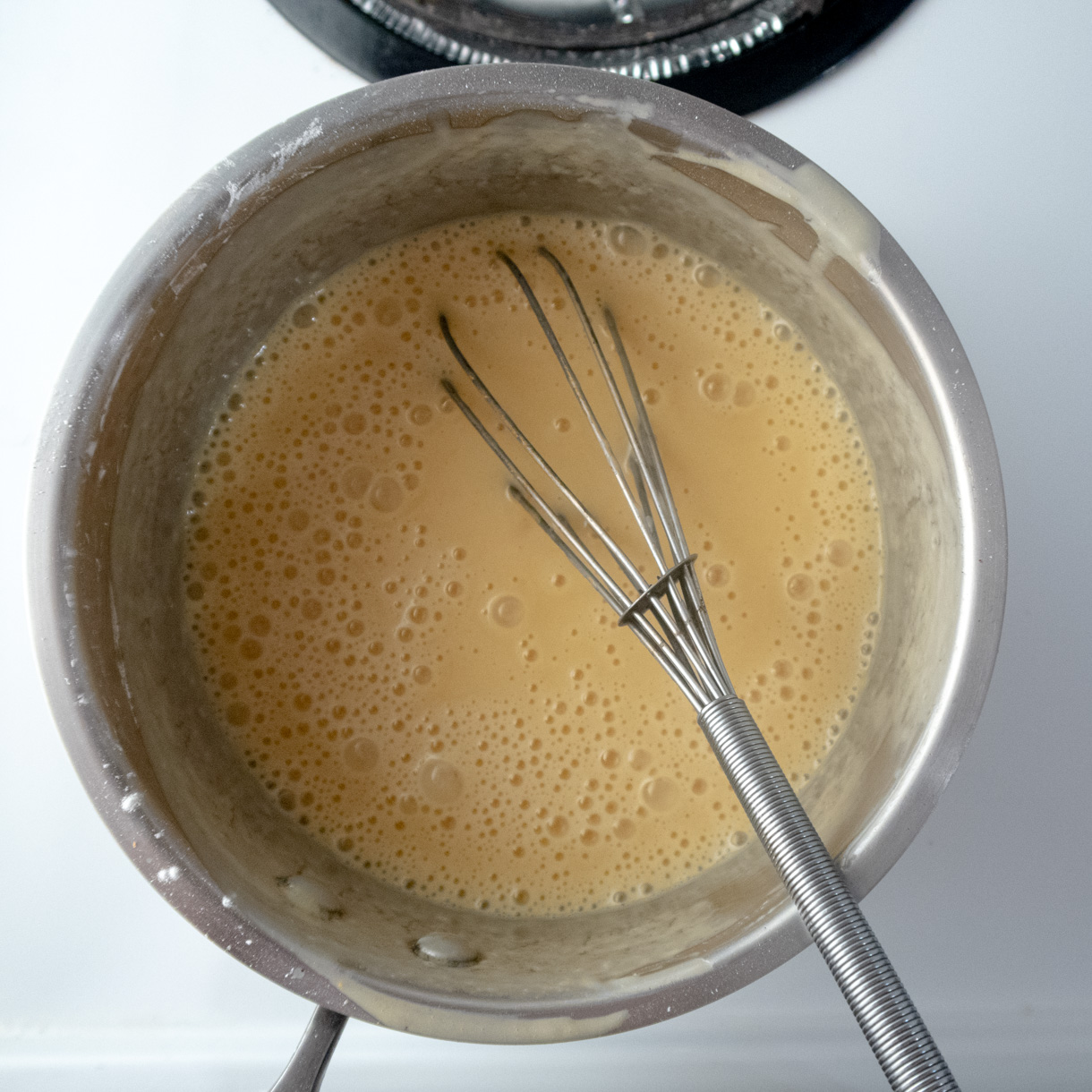 The passionfruit curd ingredients mixed in a saucepan before the cooking process.