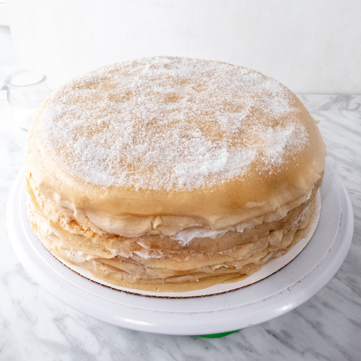 Vegan mille crepe cake with a thin layer of raw sugar on the top.