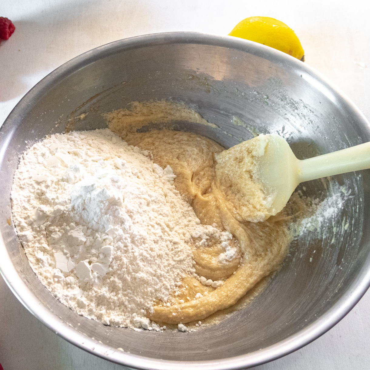 Large bowl with the mixed wet ingredients on the bottom and the dry ingredients on the left side of the bowl.