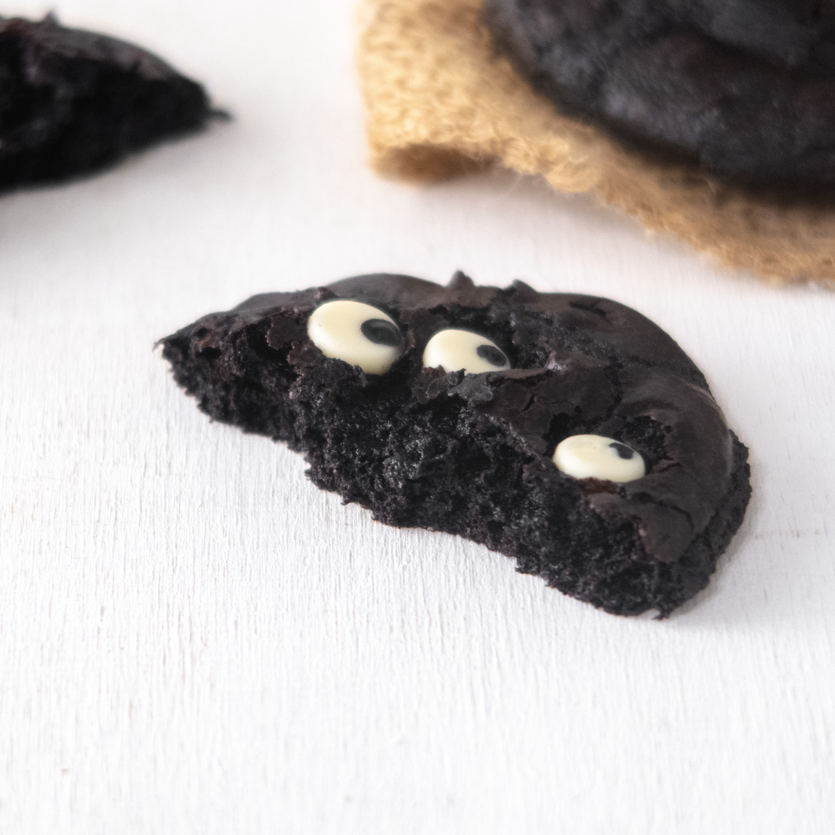 A half-eaten cookies on a white backgorund, showing the texture of the cookie.