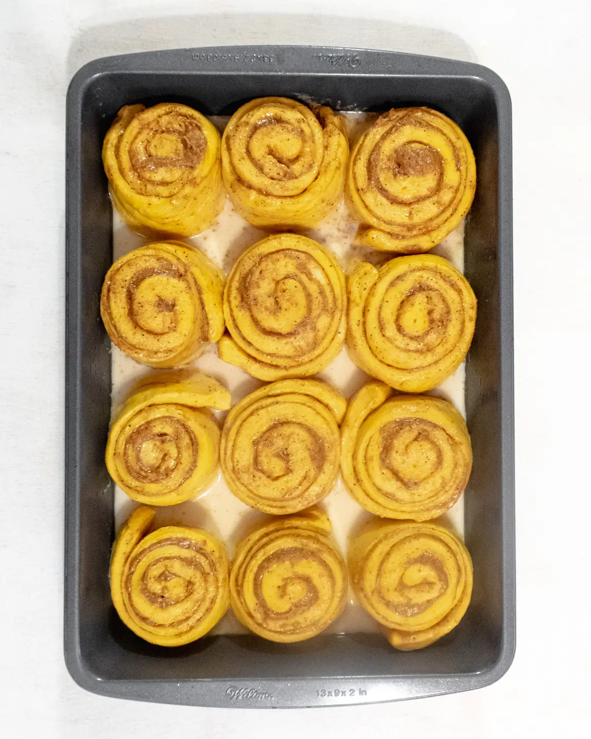 Proofed vegan pumpkin cinnamon rolls that have doubled in size.