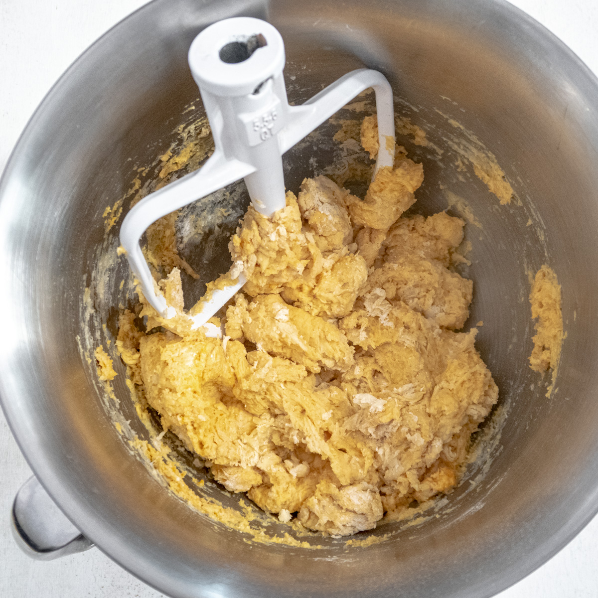 Shaggy dough made with the paddle attachment in the bowl of the stand mixer.