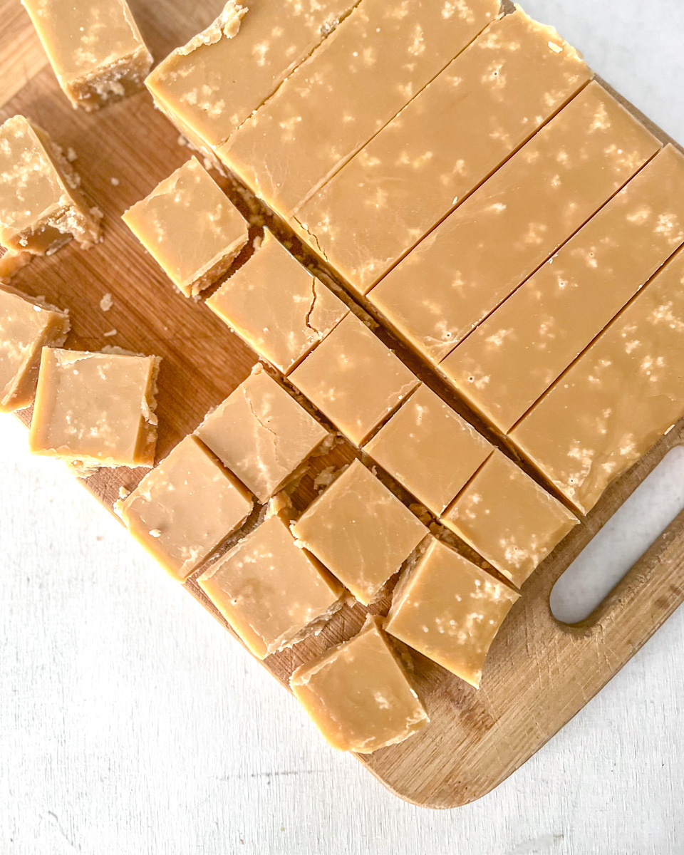 A Vegan sucre à la crème slab being cut into squares on a cutting board.