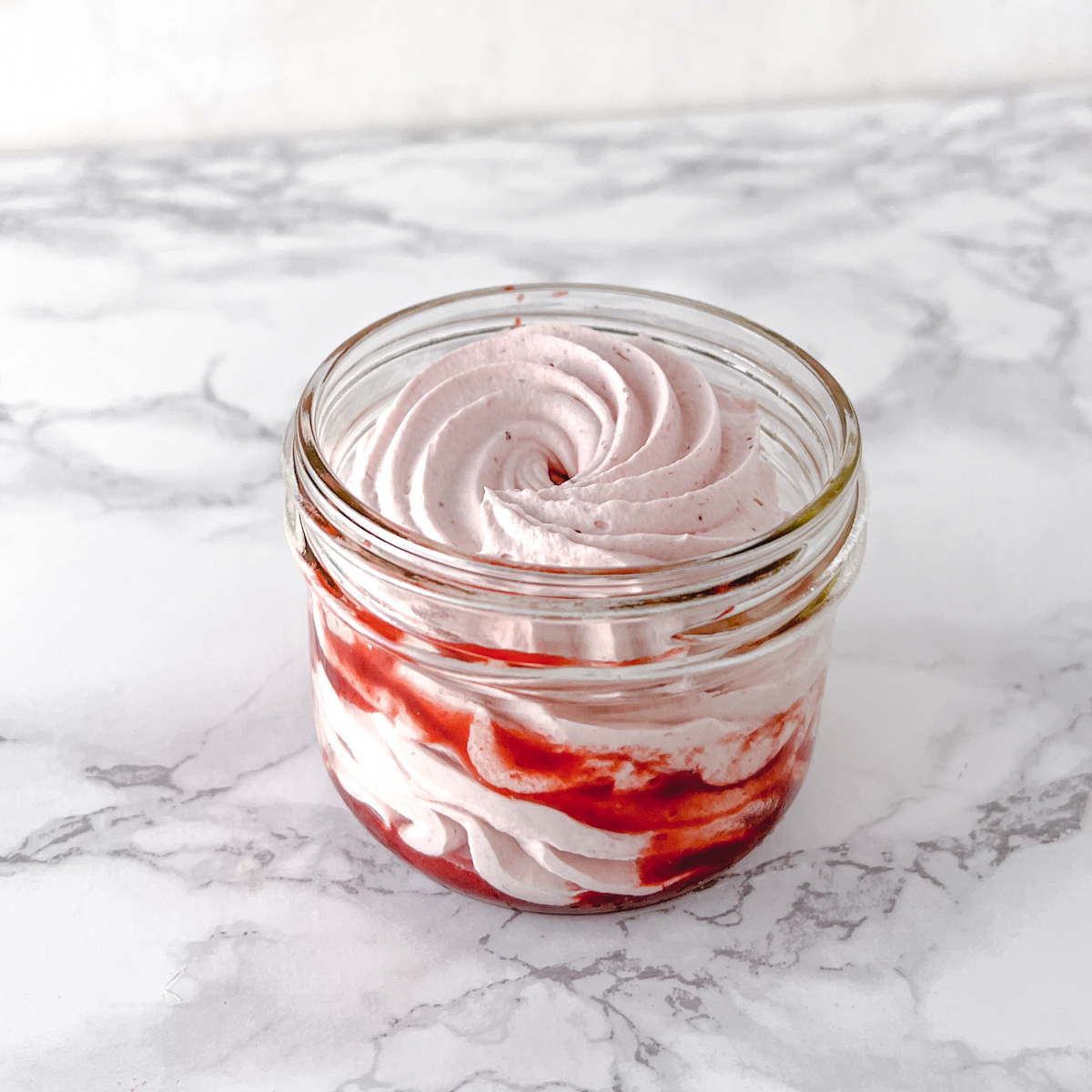 A large jar of vegan white chocolate and strawberry mousse.