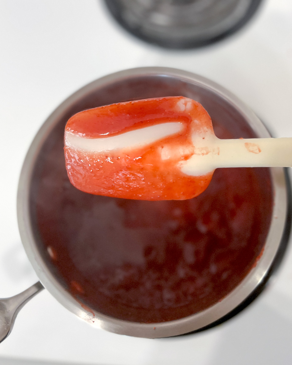 Making the reduced strawberry puree in a saucepan.