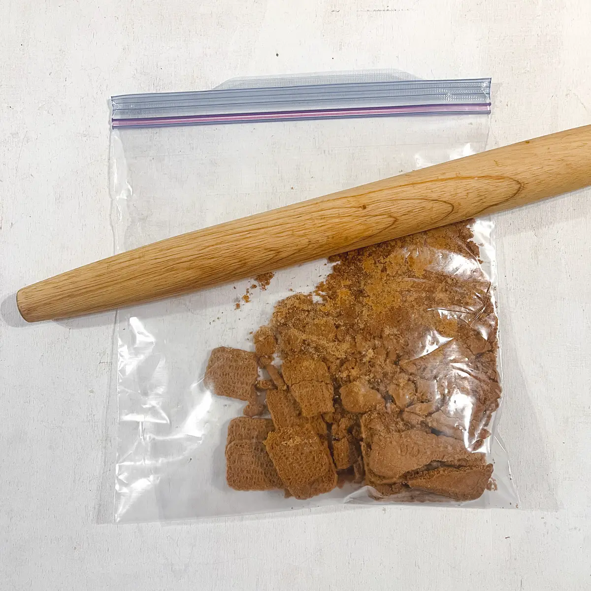 Crushing cookies in a plastic bag with a rolling pin