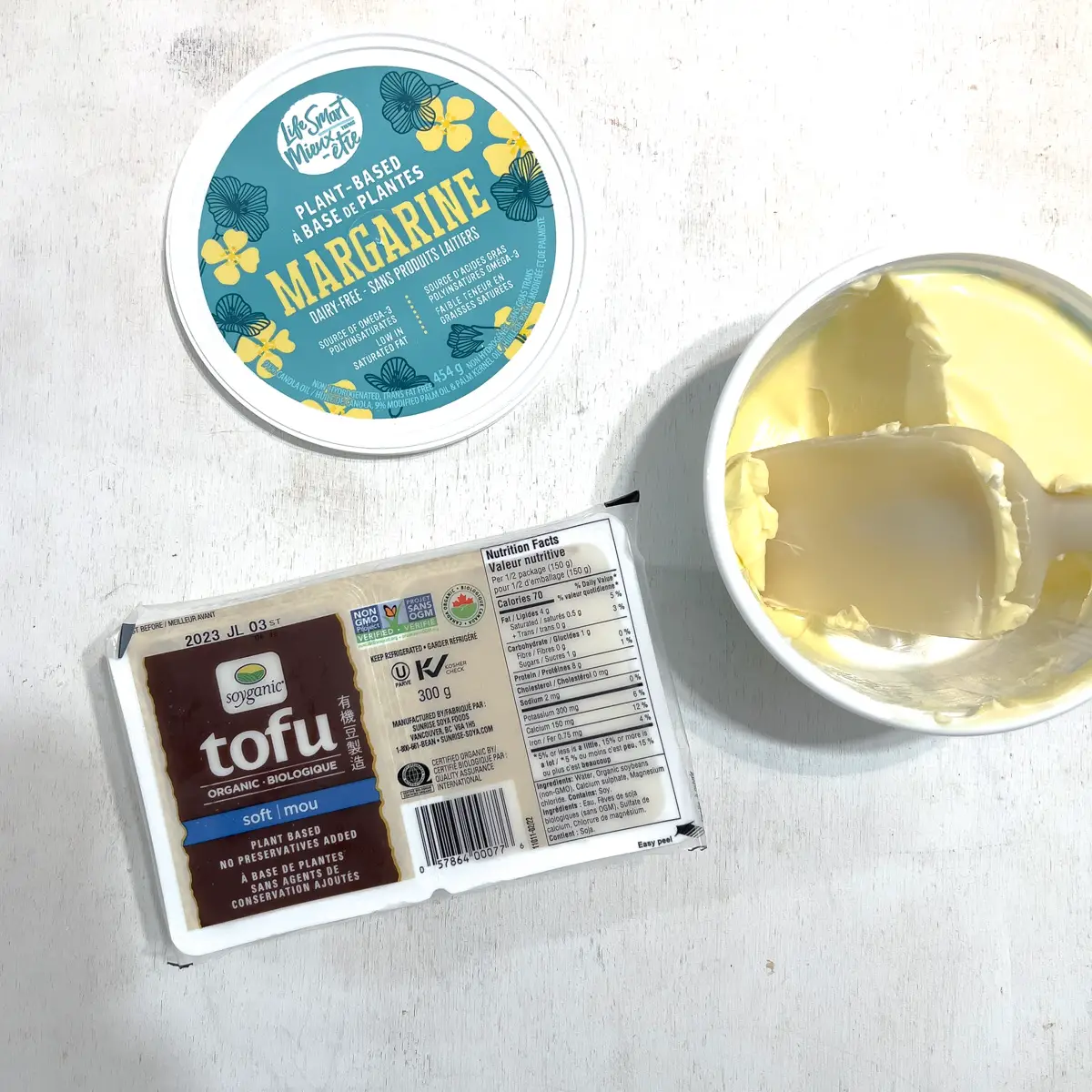 Tofu package and  vegan margarine on a white background.